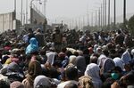 Afghans gather on a roadside near the military part of the airport in Kabul on Aug. 20.