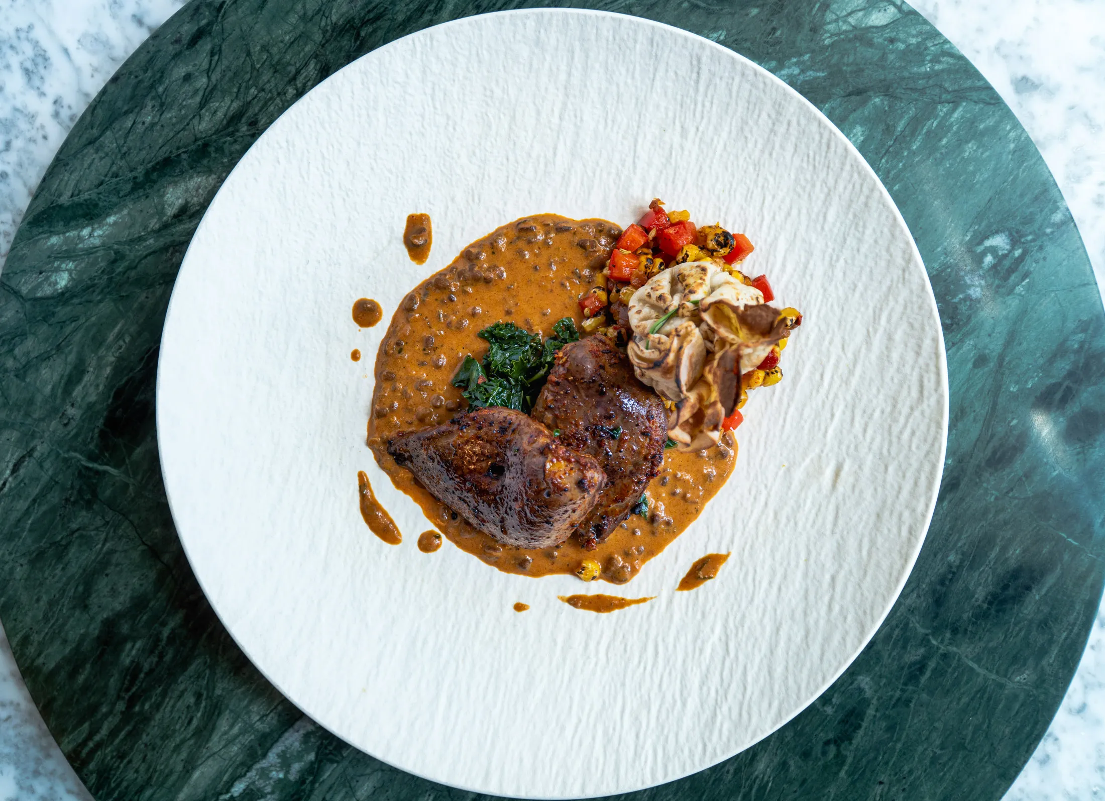 Spiced-clove smoked-grouse&nbsp;breast, chickpea bread, hot-sweet pumpkin and game keema, served with creamy black lentils.