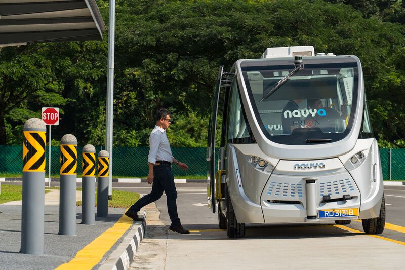 An engineer walks towards a Navya autonomous electric bus. Image: Nicky Loh/Bloomberg