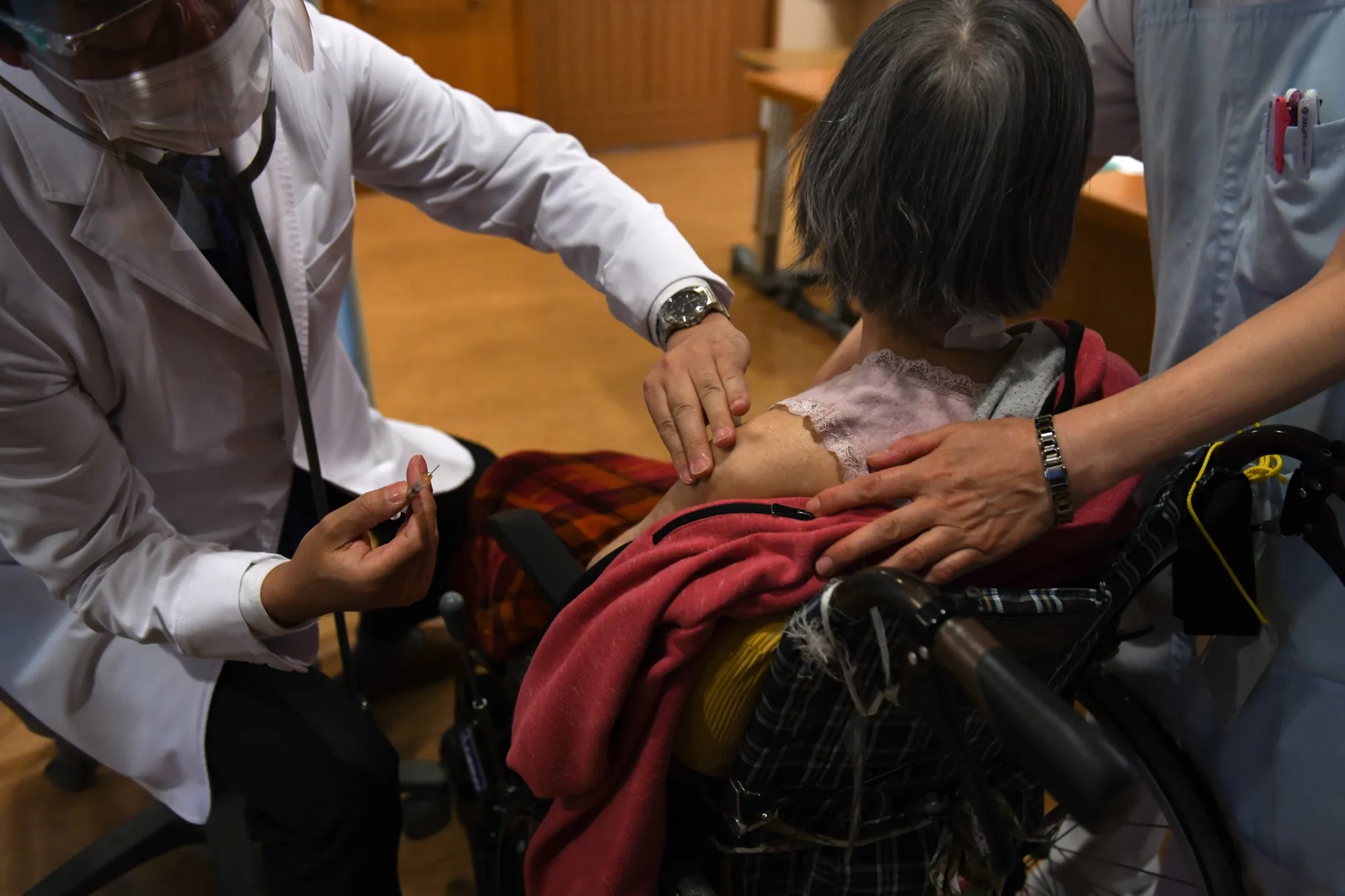 A healthcare worker administers a dose of the Pfizer-BioNTech Covid-19 vaccine at a nursing home in Kawasaki on April 12.
