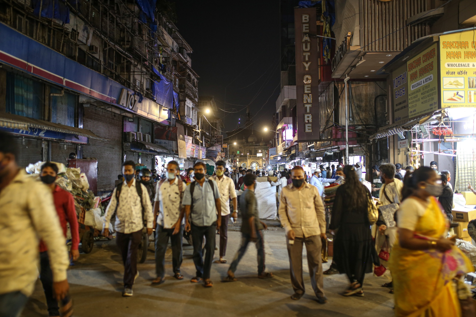 Pedestrians walk through Crawford Market at night in Mumbai, India, March 31.