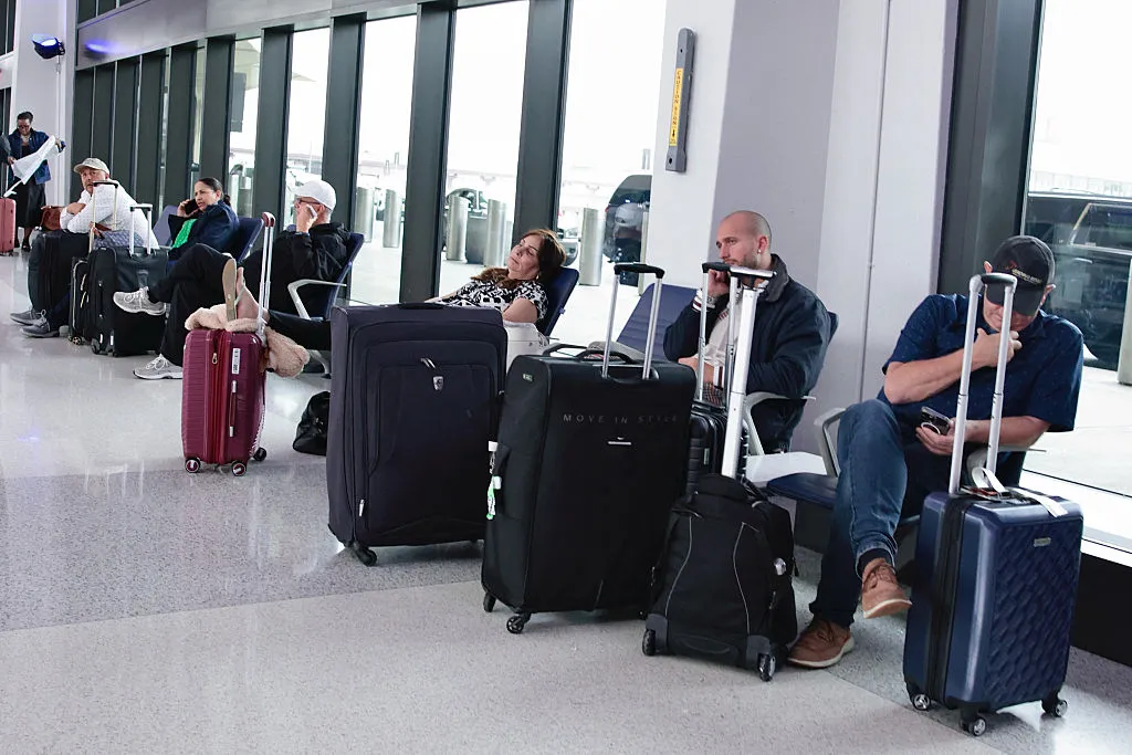 Passengers sit at the waiting area at Newark Liberty International Airport in Newark, on May 7. 