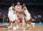 Donte DiVincenzo celebrates with teammates after defeating the Michigan Wolverines.