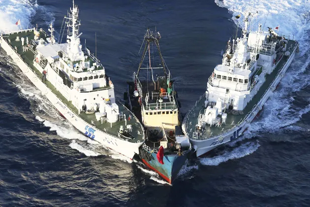 A boat is surrounded by Japan Coast Guard patrol boats after activists descended on Uotsuri Island, one of the islands of "Senkaku" (Japanese) and "Diaoyu" (Chinese), in the East China Sea