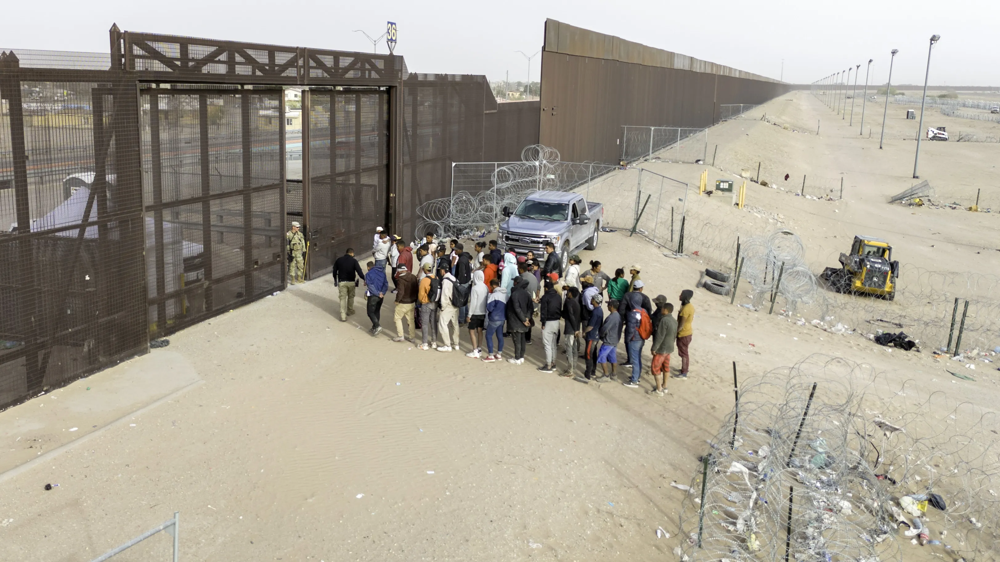 Immigrants wait for transport and processing after crossing the US-Mexico border in El Paso, Texas on March 13.