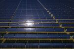 Solar panels stand at a solar generating facility 