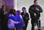 People embrace after being reunited as a police officer stands by following a shooting at Fashion Outlets of Chicago mall in Rosemont, Illinois, on&nbsp;March 25.