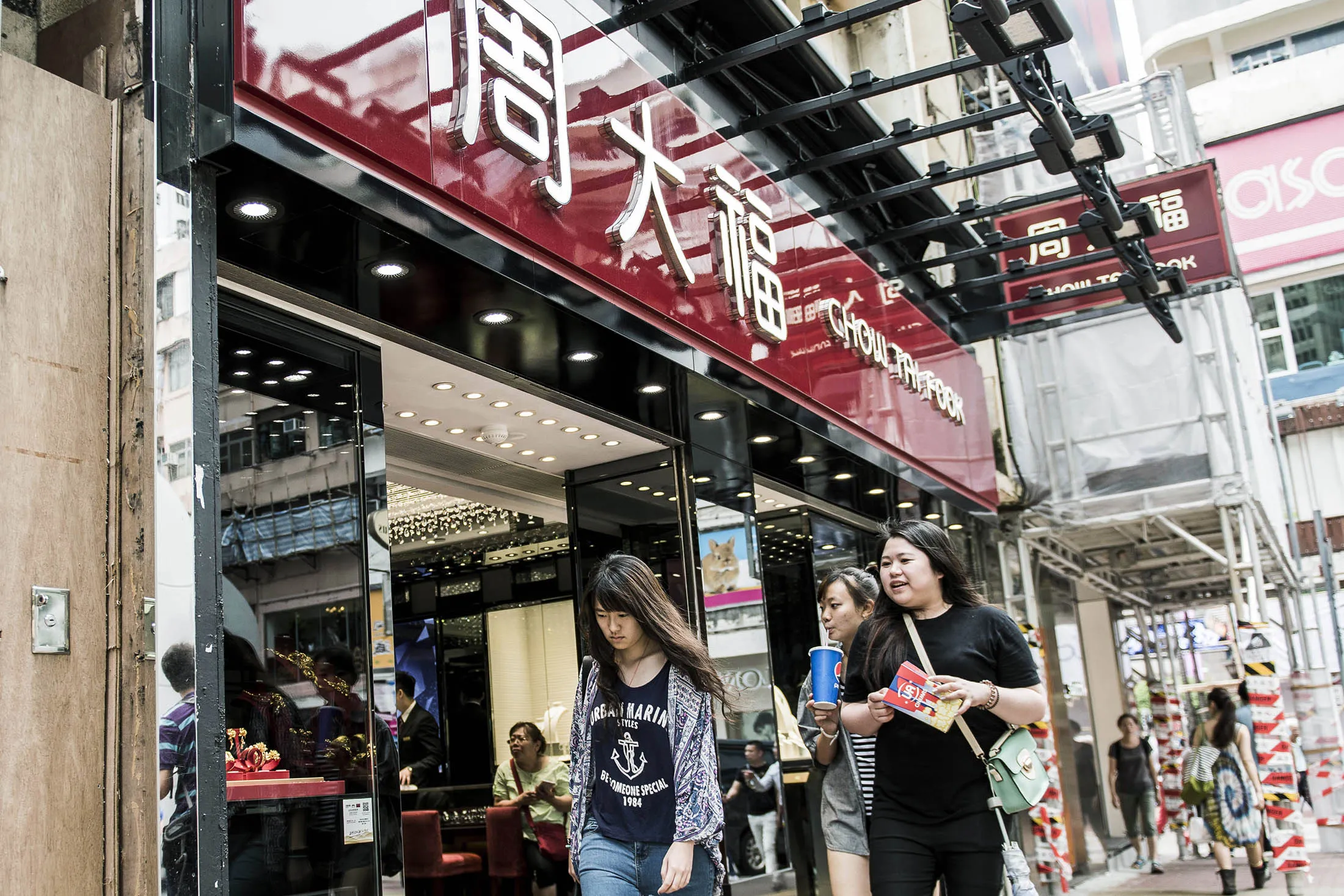 Pedestrians walk past a Chow Tai Fook jewelry store in Causeway Bay, Hong Kong.

