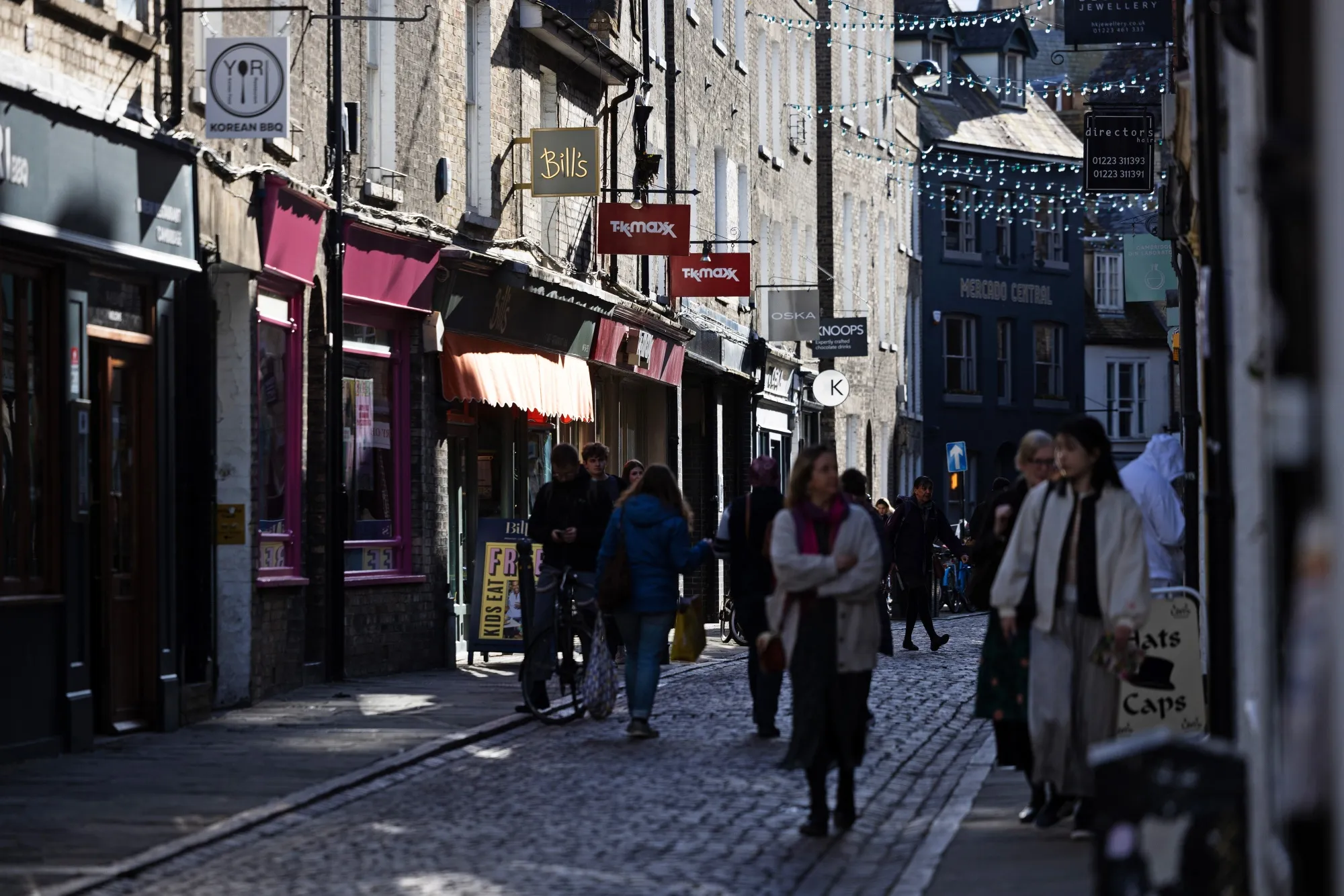 Pedestrians pass stores in Cambridge, UK.