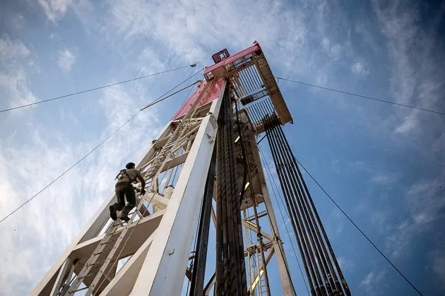 Jeff Allyn of Raven Drilling climbs to the top of a derrick while drilling for oil in the Bakken shale formation outside Watford City, N.D.