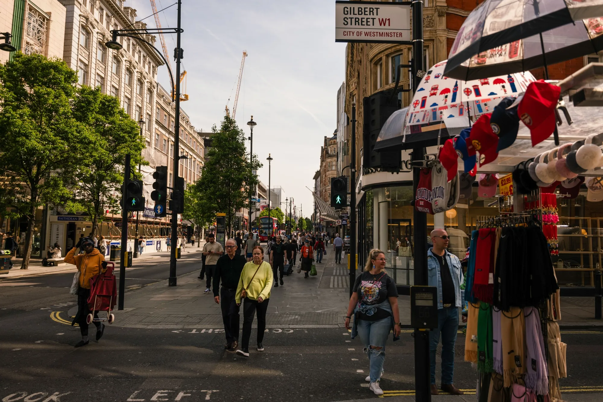 Shoppers cross Gilbert Street in Central London, UK.