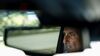 The face of the Volusia County Sheriff Michael Chitwood is visible in the rearview mirror of a car. He is a white male with a graying mustache.