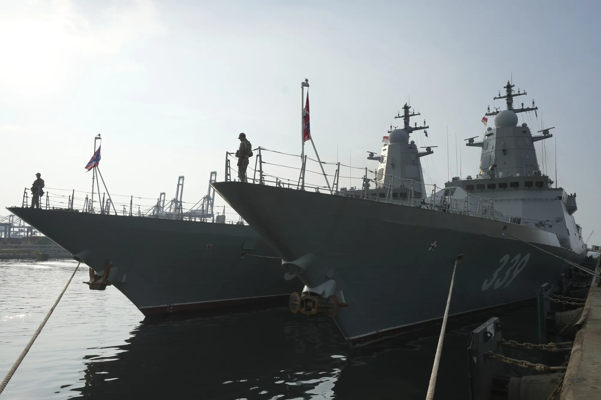Personnel stand on the bow of Russian Navy ships.