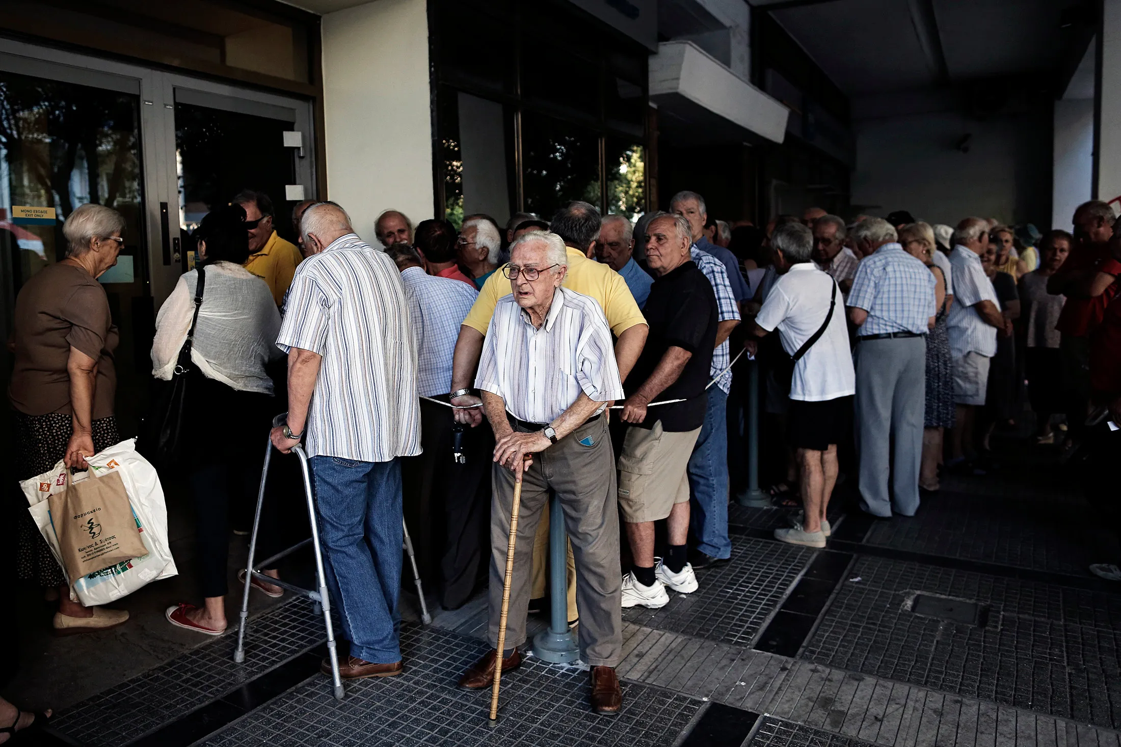 Pensioners queue to enter a National Bank of Greece branch to collect their pensions in Thessaloniki on Thursday, July 9, 2015.
