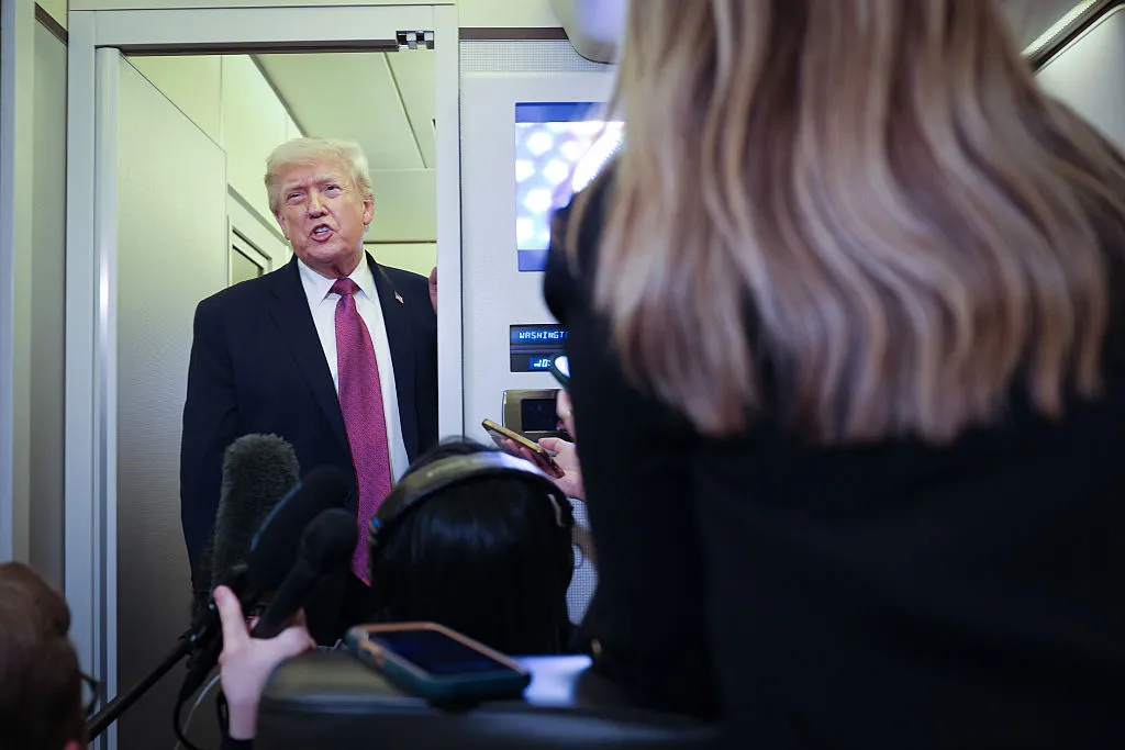 大統領専用機内で記者団に話すトランプ氏