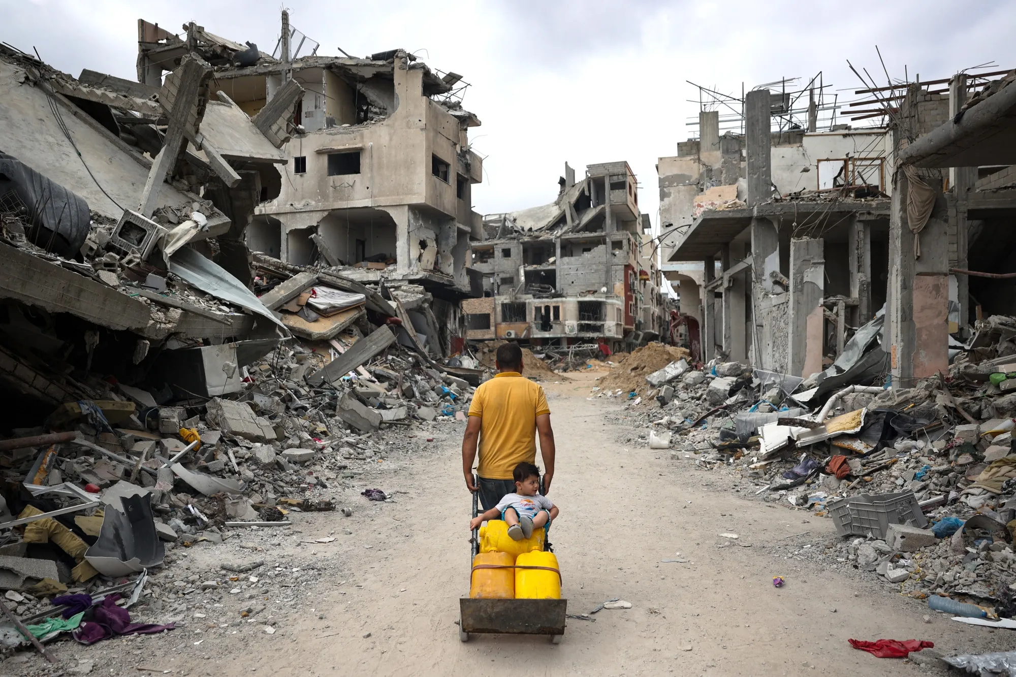 A Palestinian man pulls a cart on a road of destroyed buildings in Khan Yunis on May 2.