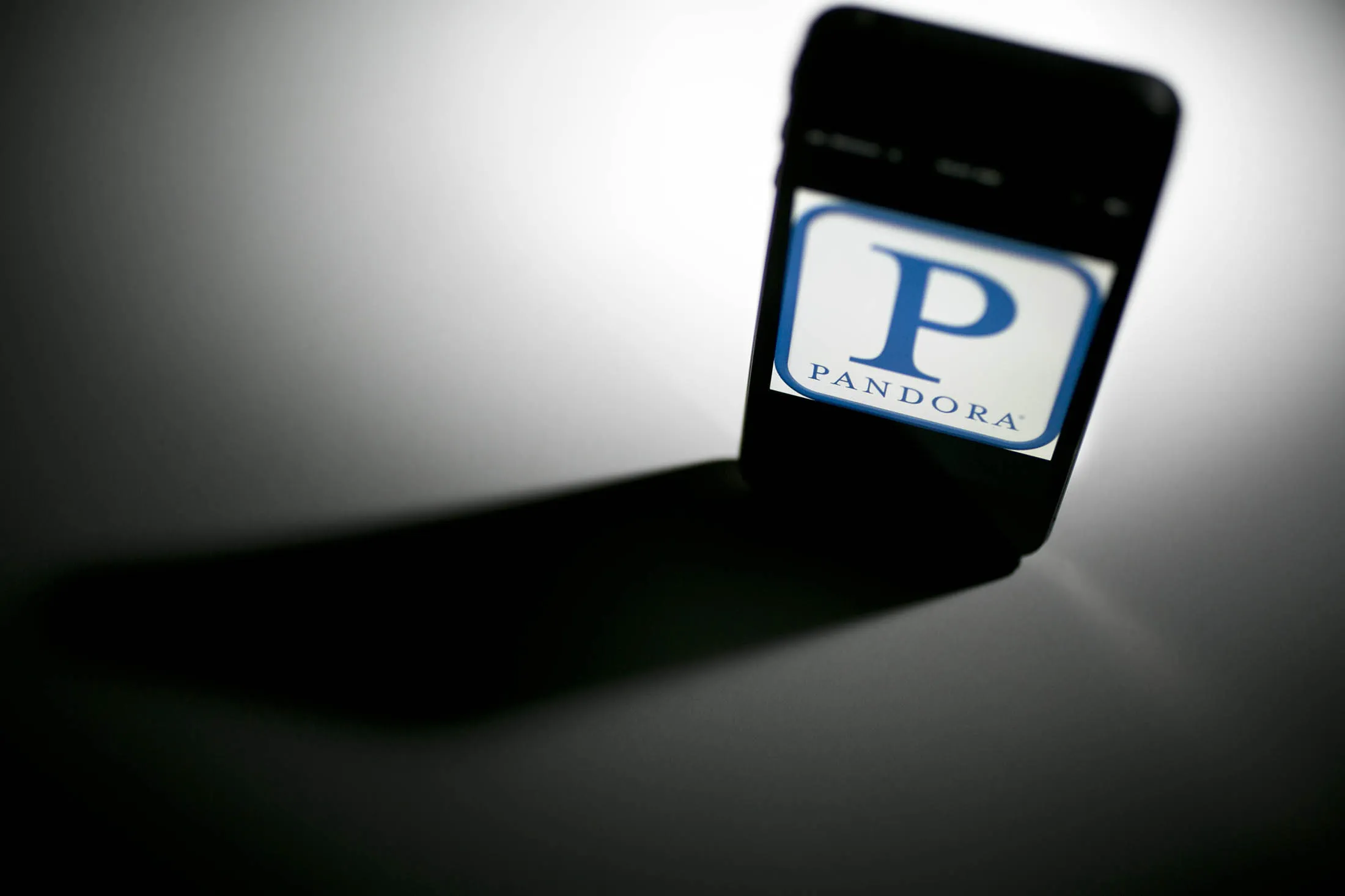 The Pandora Media Inc. logo is seen on an Apple Inc. iPhone displayed for a photograph in Washington, D.C., U.S., on Tuesday, Sept. 17, 2013. Pandora Media Inc., owner of the biggest Web radio service, filed to raise about $231 million by issuing new shares after its stock more than doubled this year.
