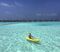 Bliwise kayaking in the Maldives among a sea of overwater bungalows.