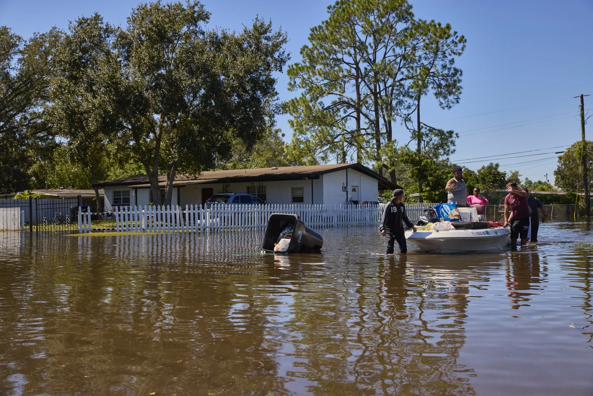 A resident assists neighbors through flooded streets in Orlando, Florida, on Sept. 30.