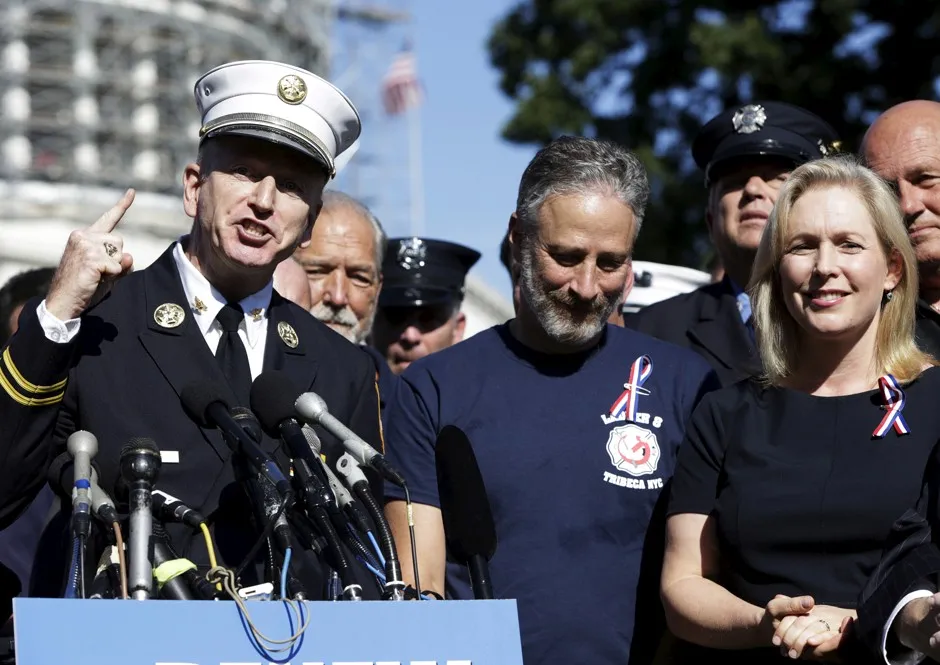 Legislative Director of the Uniformed Fire Officers Association Richard Alles stands alongside Zadroga Act supporters John Stewart and Senator Kirsten Gillibrand.