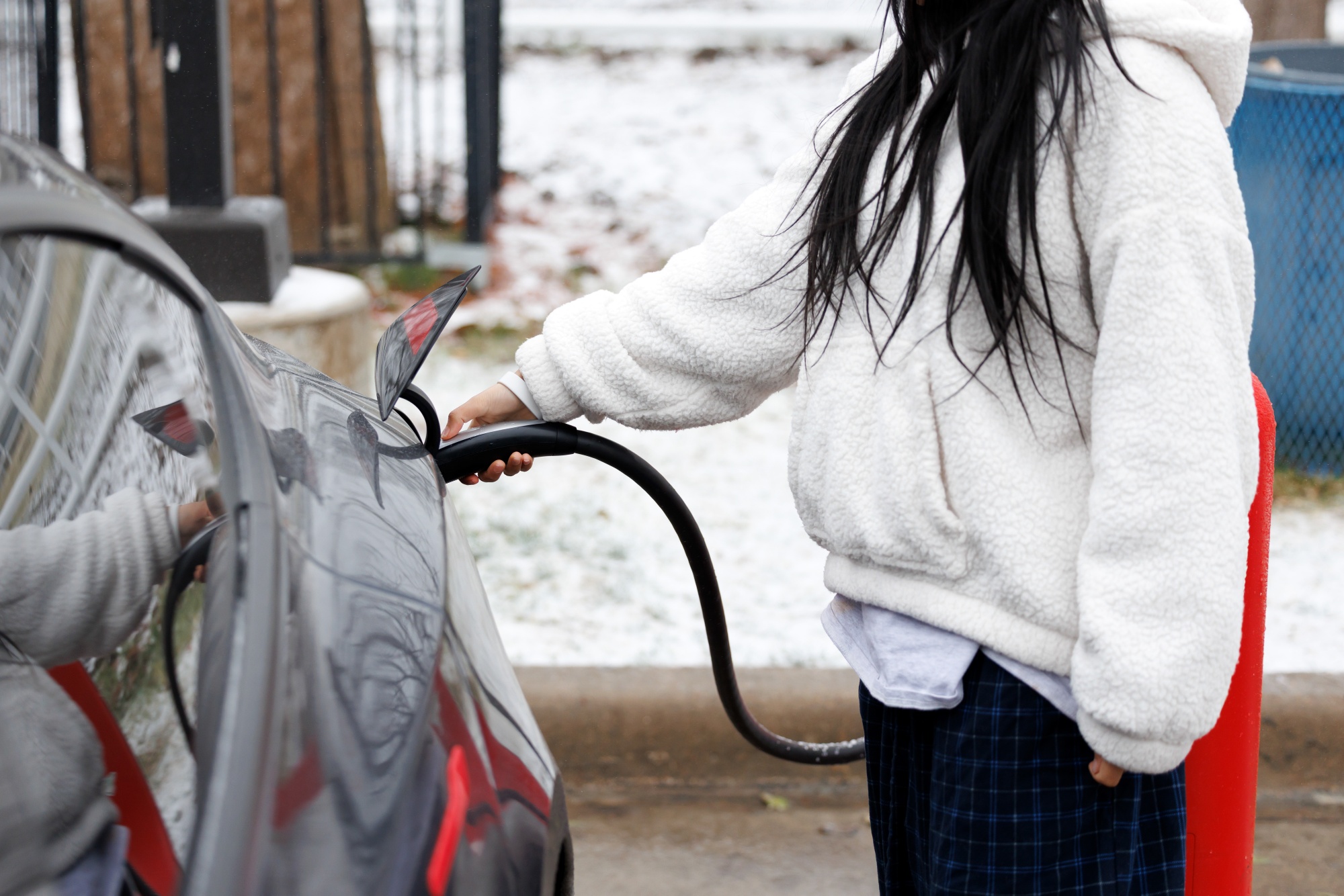 A driver uses a Tesla Inc. electric vehicle (EV) charger to charge a vehicle during a winter storm in Dallas, Texas, US, on Saturday, Jan. 24, 2026. A massive US storm stretching from the southern Rocky Mountains to New England triggered a grid emergency in the country's midsection, prompted cascading travel disruptions and is expected to dump heavy snow on New York and Boston. Photographer: Mark Felix/Bloomberg