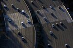 Cars move along during rush hour traffic on the US 101 Freeway in this aerial photograph taken over the Sherman Oaks neighborhood of Los Angeles, California, U.S., on Friday, July 10, 2015.
