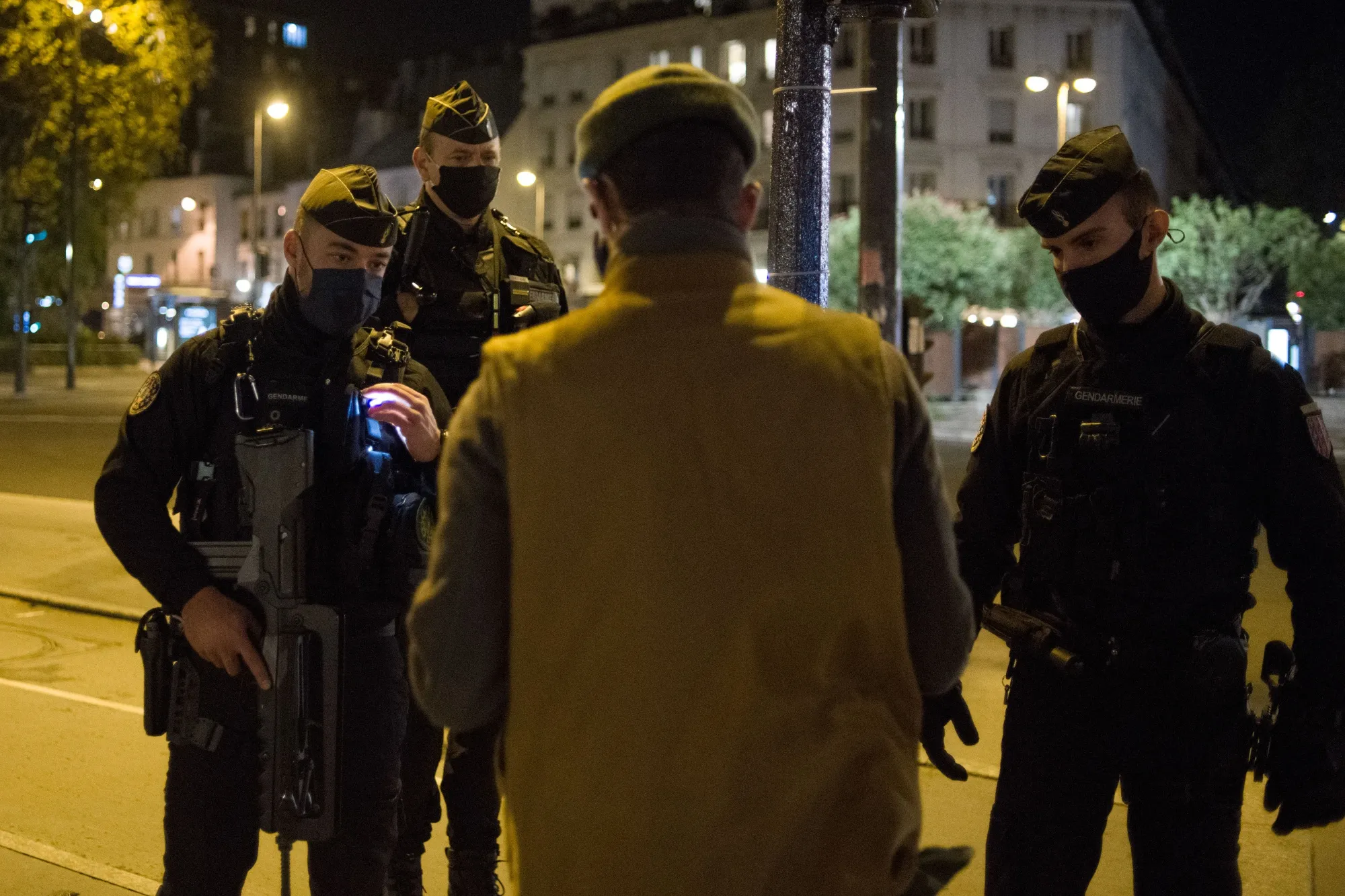 Police officers check a pedestrians paperwork as a curfew comes into effect in Paris, France, on Saturday, Oct. 17, 2020. President Emmanuel Macron will confine residents of nine of the country's biggest cities to their homes between 9 p.m. and 6 a.m. for four weeks starting on Saturday.