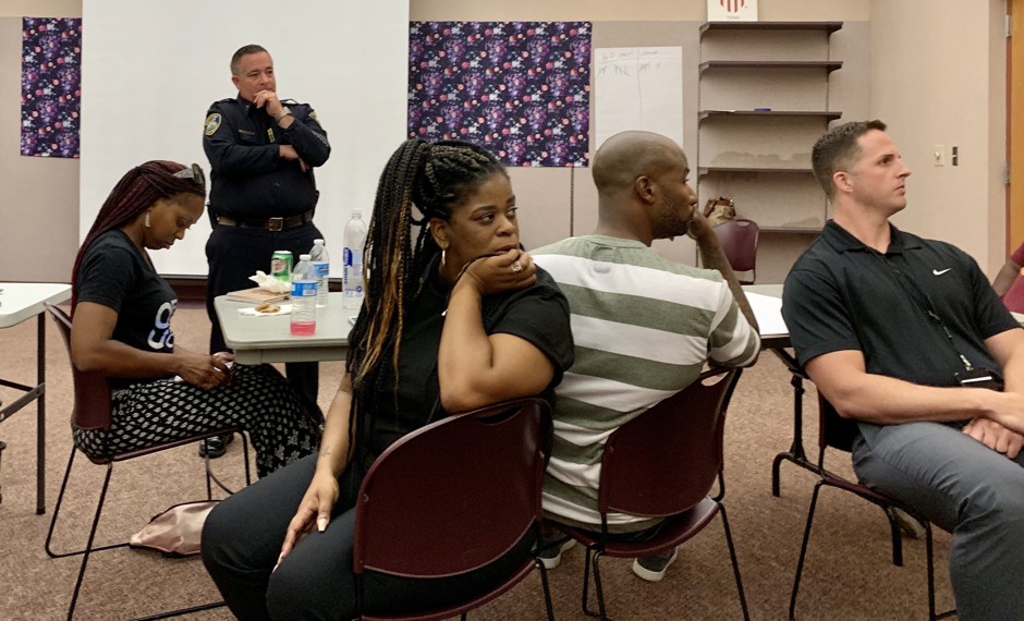 Captain Scott Meadors (in uniform) of the Stockton Police Department oversees a trust-building workshop with community members and other police officers.