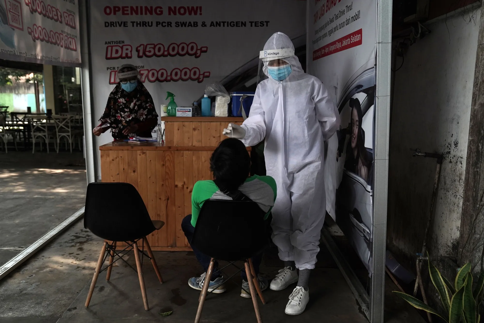 A healthcare worker collects a swab sample at a coronavirus testing site in Jakarta on July 15.