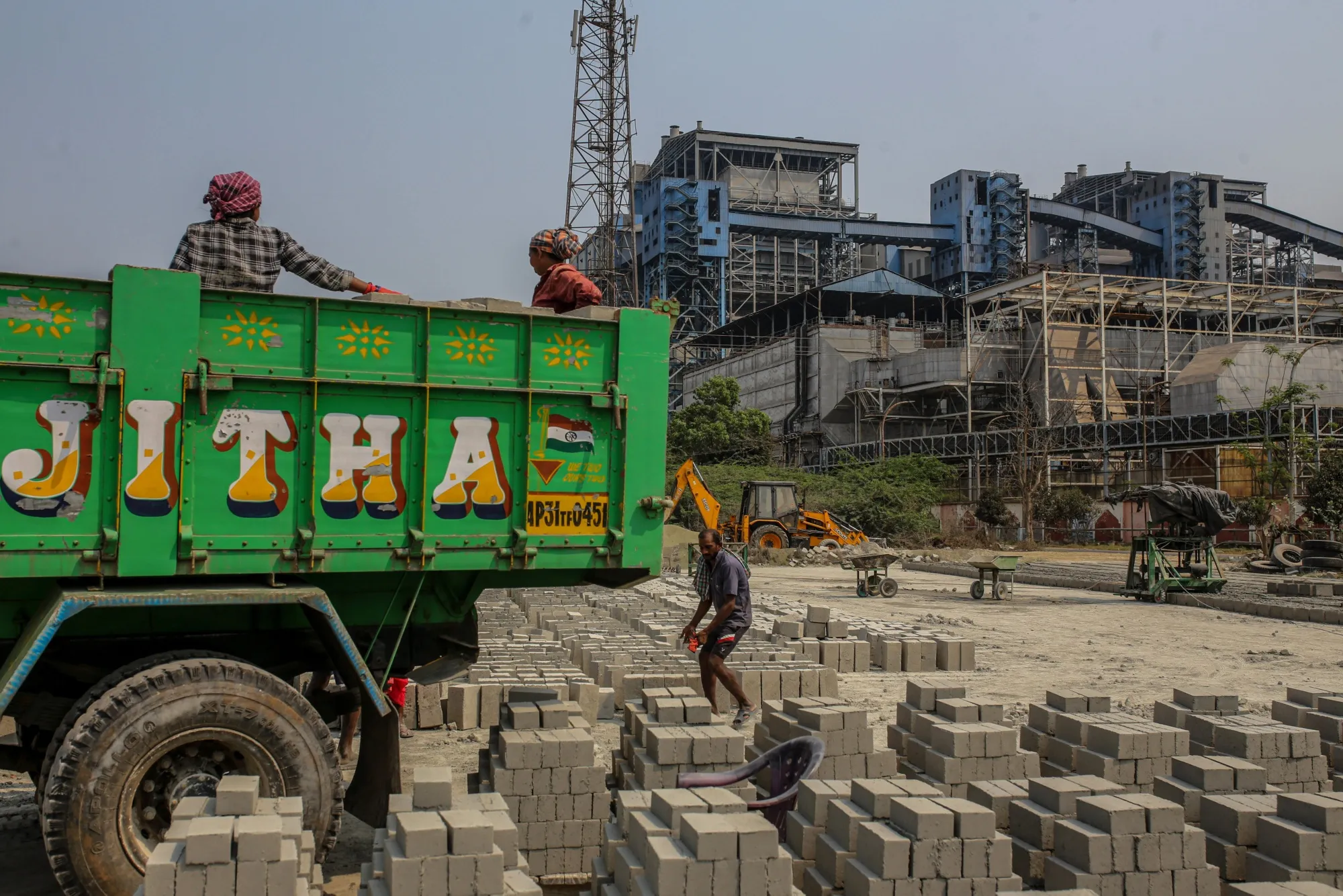 Workers at a concrete block manufacturing factory near a coal-fired thermal power plant in the outskirts of Visakhapatnam, Andhra Pradesh, India.