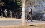 Armed Malawian policemen walk through a cloud of teargas as they disperse demonstrators&nbsp;in Lilongwe on June 6, 2019.