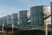 Oil storage tanks loom behind a barbed wire fence at Louisiana’s Port Fourchon.
