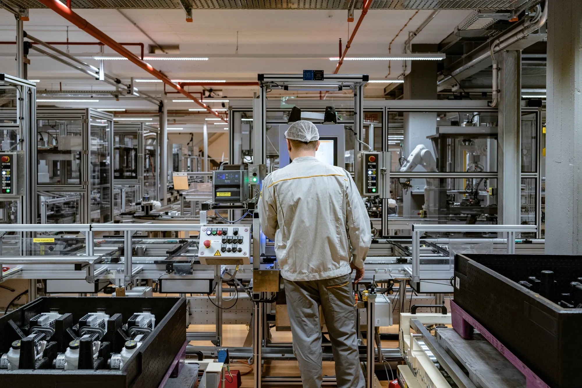 An employee operates a machine on the production line at a manufacturing plant in Frankfurt.