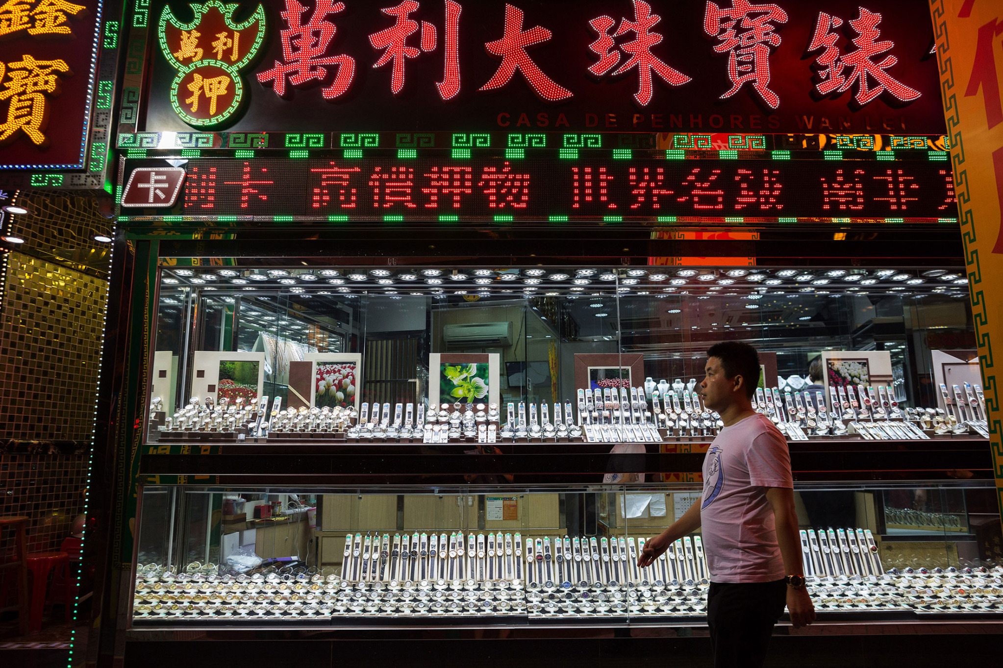 A pedestrian walks past watches on display in a store window in Macau, on Aug. 29.

