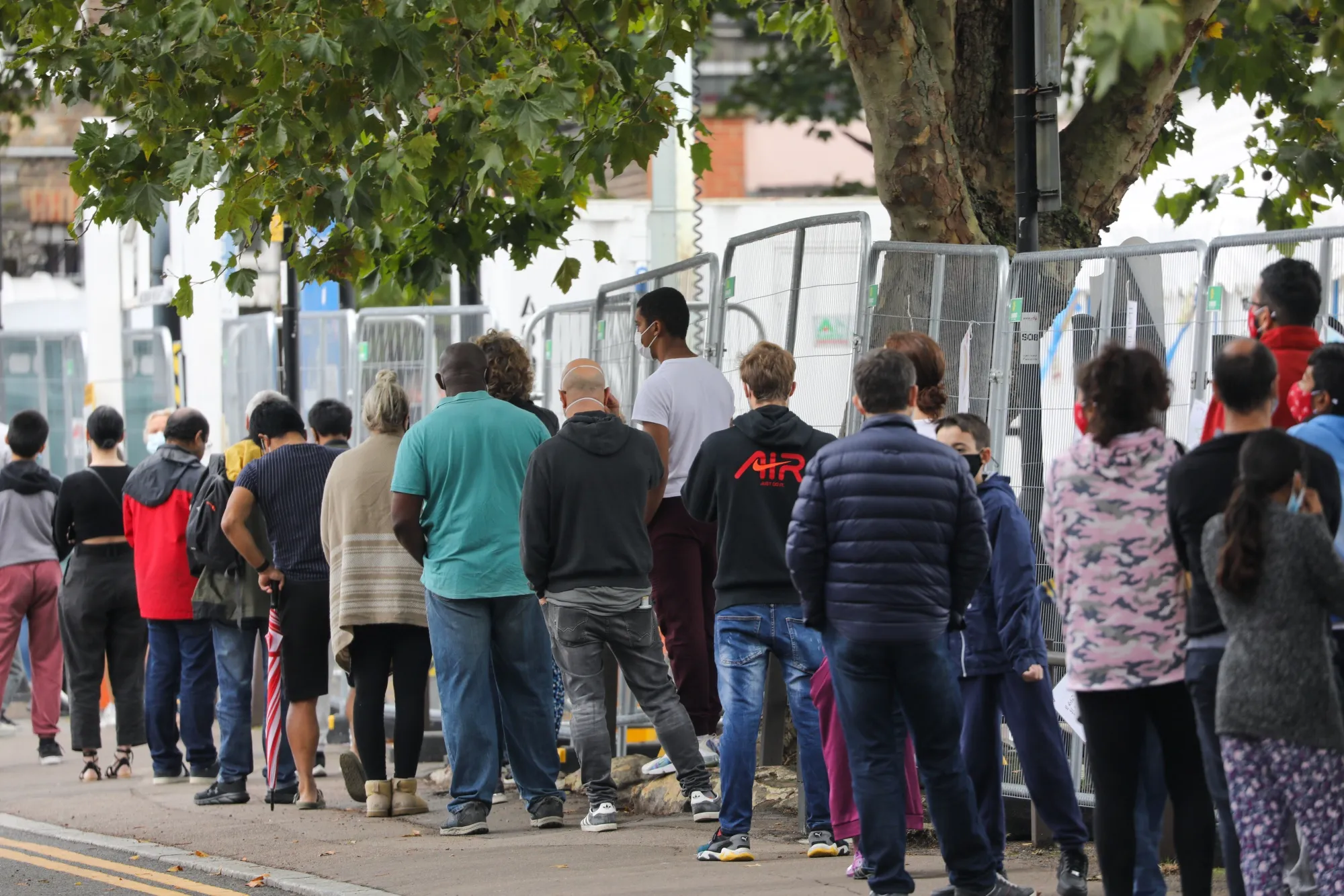 Visitors stand in line at a coronavirus walk-in testing center in north London on Sept. 23.