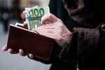A customer places euro banknotes into a purse ahead of the 171st Organization of Petroleum Exporting Countries (OPEC) meeting in Vienna, Austria, on Tuesday, Nov. 29, 2016. An OPEC deal to curtail oil production appeared in jeopardy as Iran said it won’t make cuts while Saudi Arabia insisted Tehran must be willing to play a meaningful role in any agreement.
