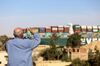 A spectator waves as the Ever Given container ship moves along the Suez Canal towards Ismailia after being freed from the canal bank in Suez, Egypt, on March 29.
