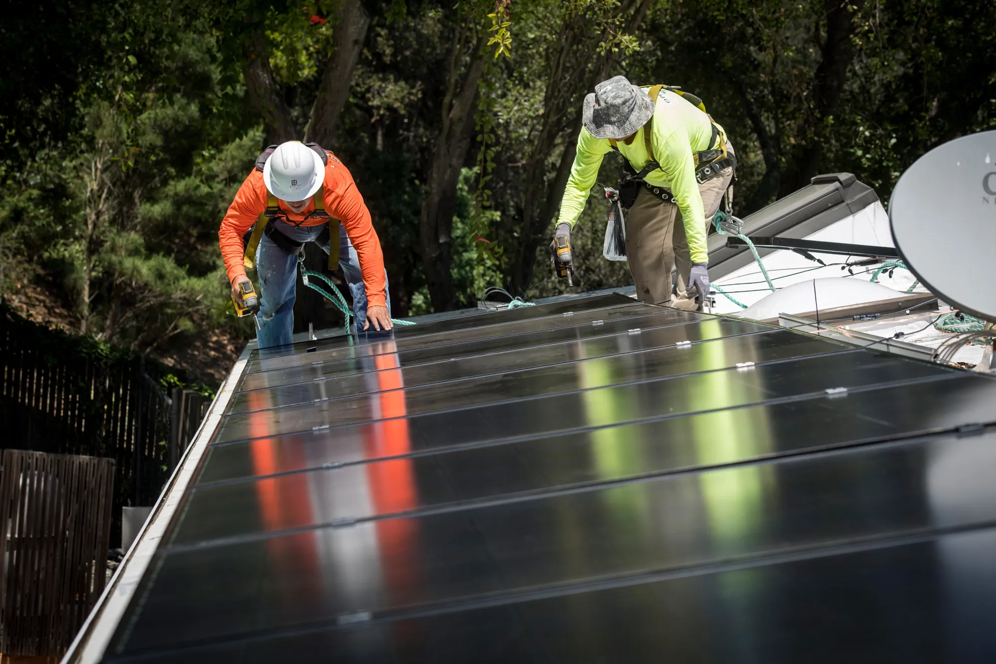 Workers install solar panels on the roof of a home in Lafayette, California.