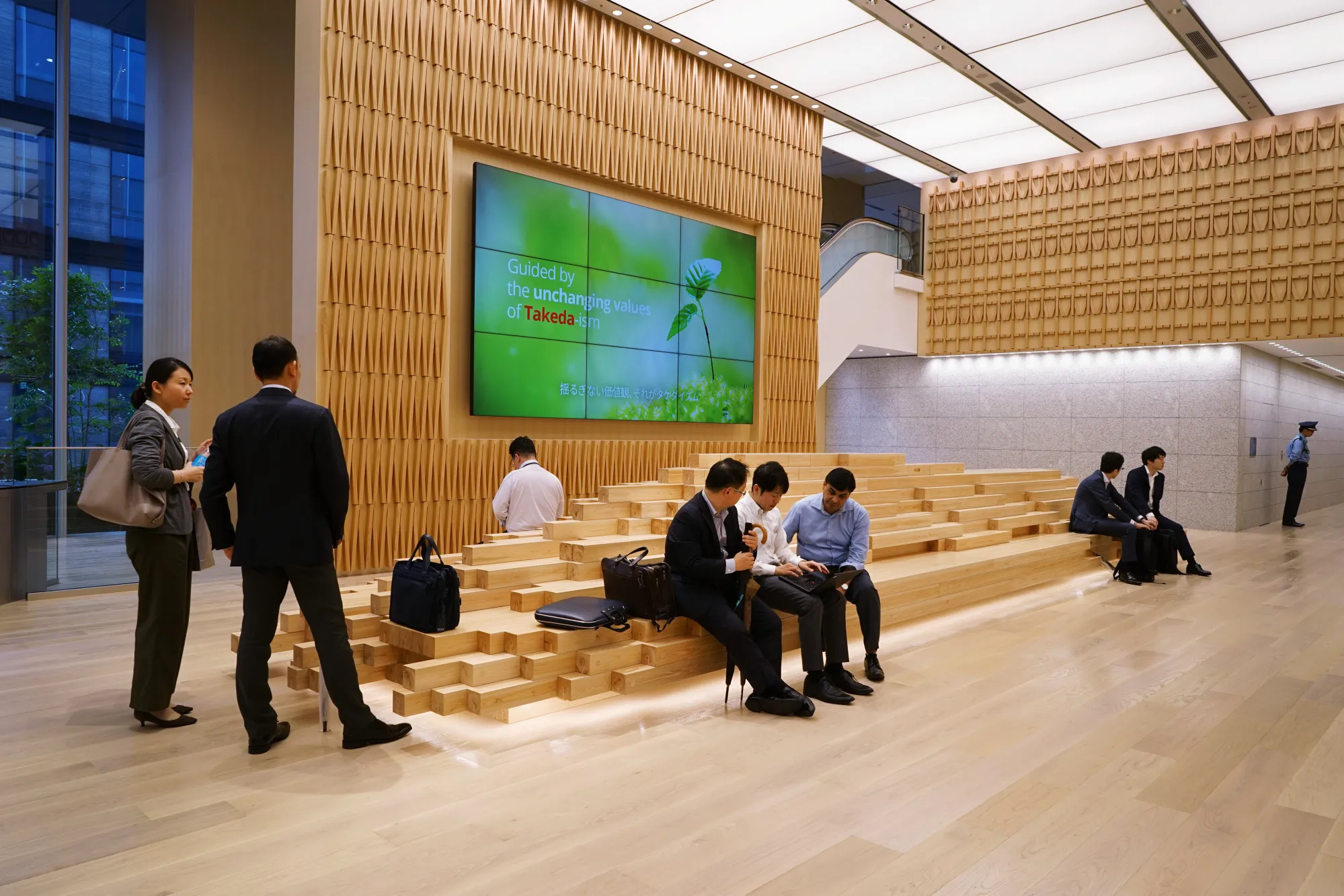 People wait at the reception hall of Takeda Pharmaceutical Co.'s global headquarters in Tokyo.