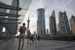 Pedestrians walk along an elevated walkway in the Lujiazui Financial District in Shanghai, China.