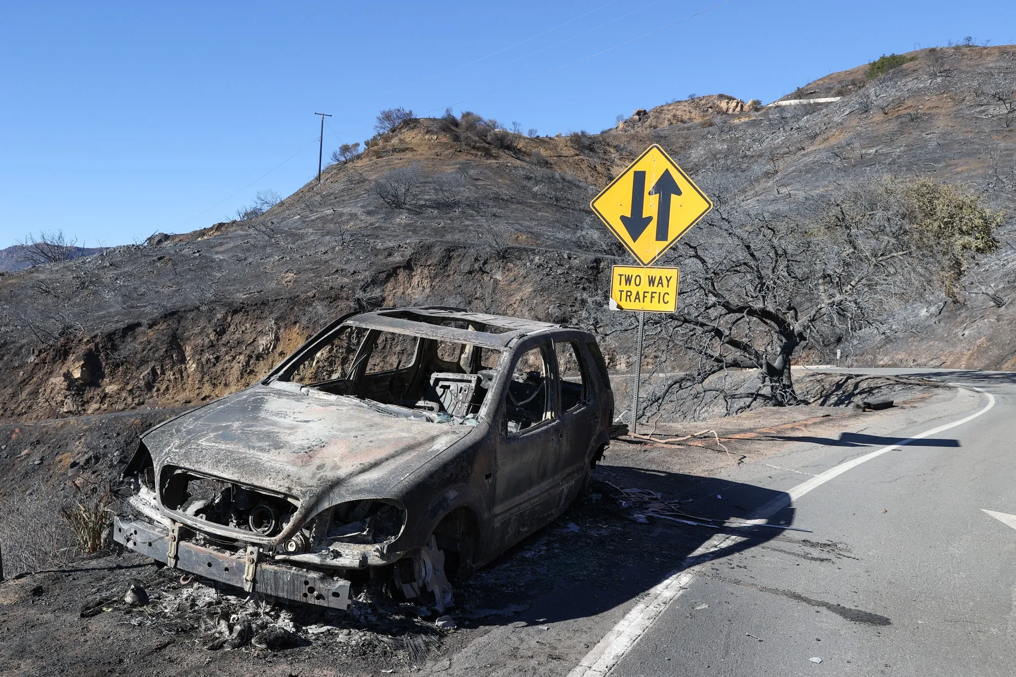 A scorched car sits beside the road in Topanga Canyon during Palisades wildfire in Los Angeles&nbsp;on Jan.&nbsp;10, 2025.