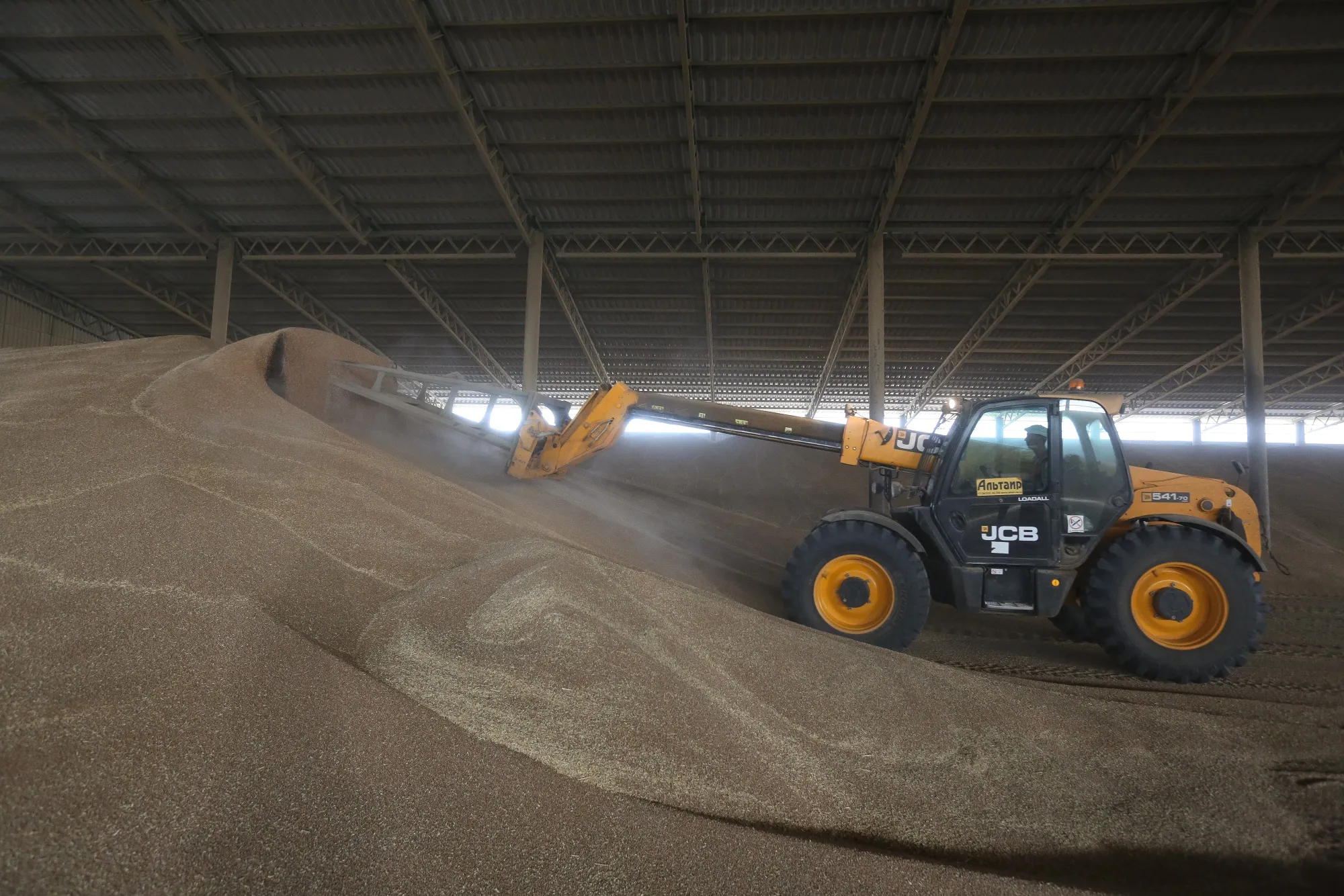 A truck piles wheat grain inside the storage facility outside Rostov, Russia.