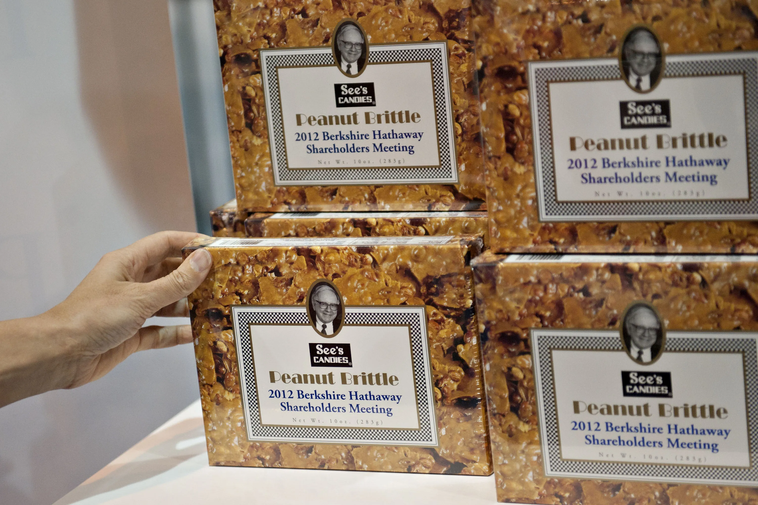 A photograph of Warren Buffett on a box of See's Candies peanut brittle