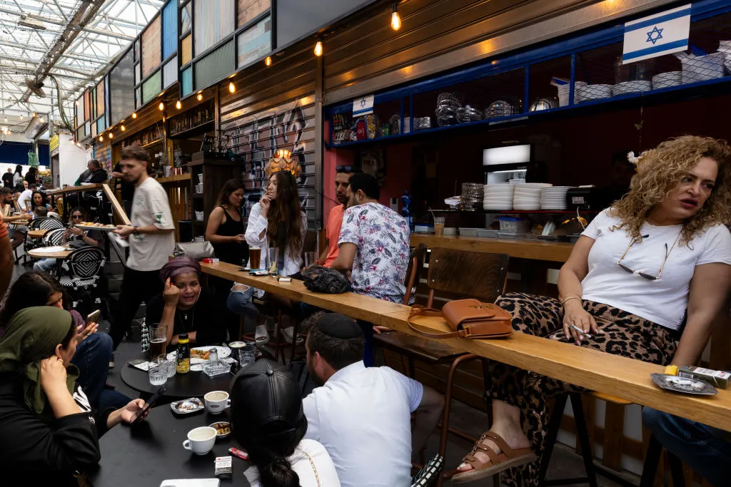 People at a bar at a food market in Netanya, April 12.