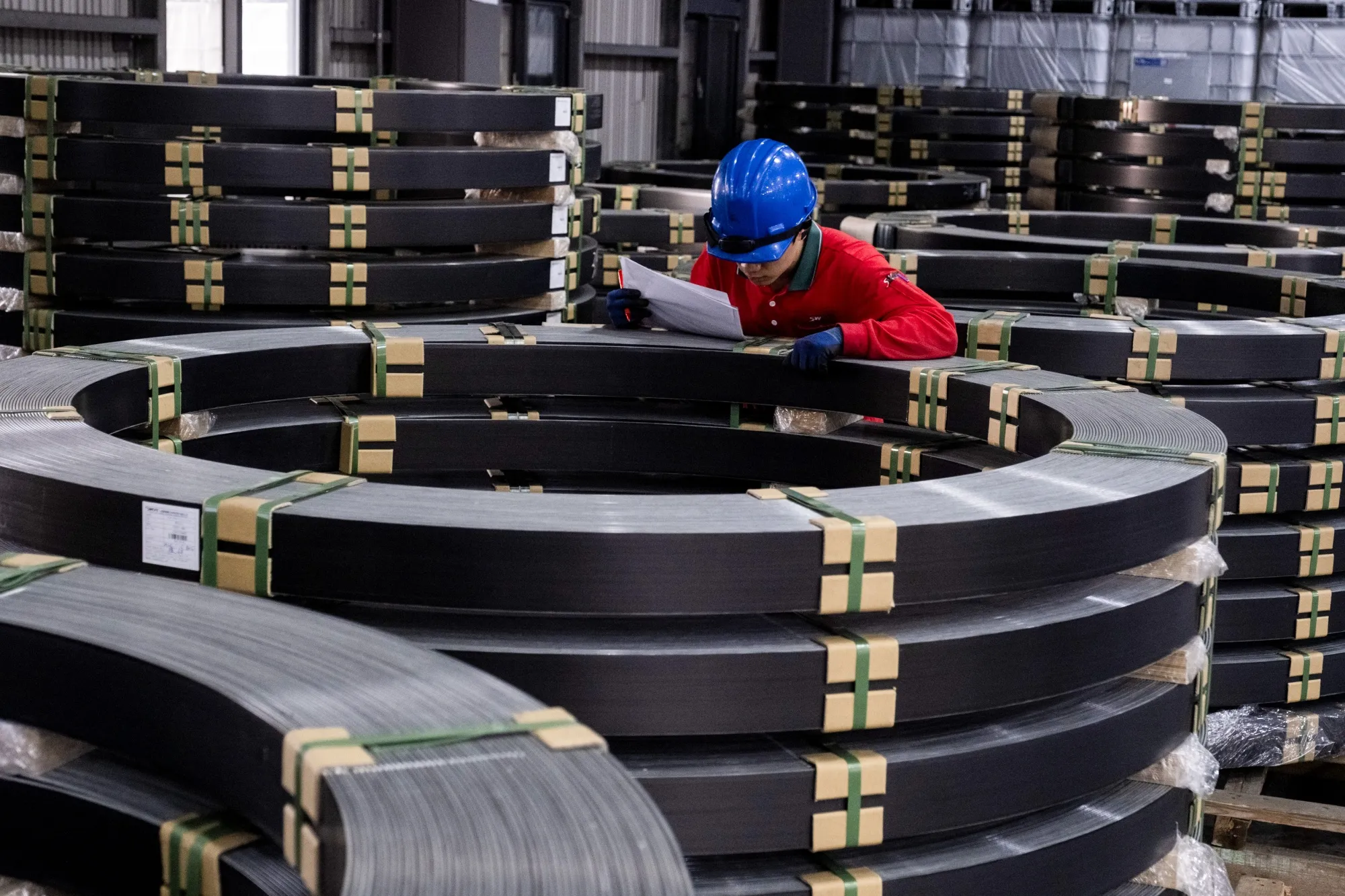 A worker checks the carbon-fiber composite made for wind blades stored at the Swancor Holding factory in Nantou, Taiwan.