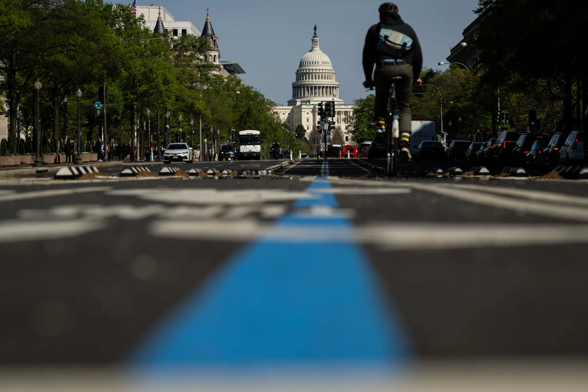 The US Capitol behind a cyclist in a bike lane on Tuesday, April 7
