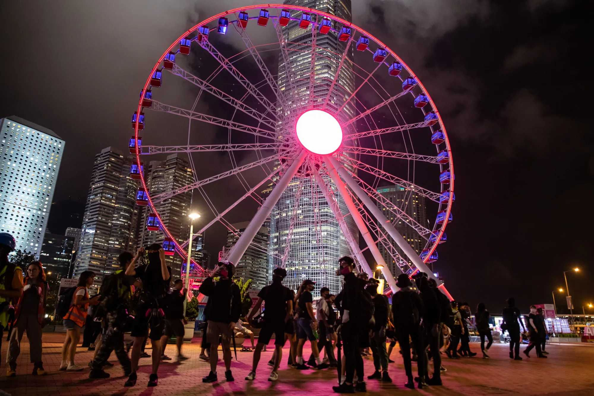 Demonstrators walk past a ferris wheel during a strike rally on Sept. 3.