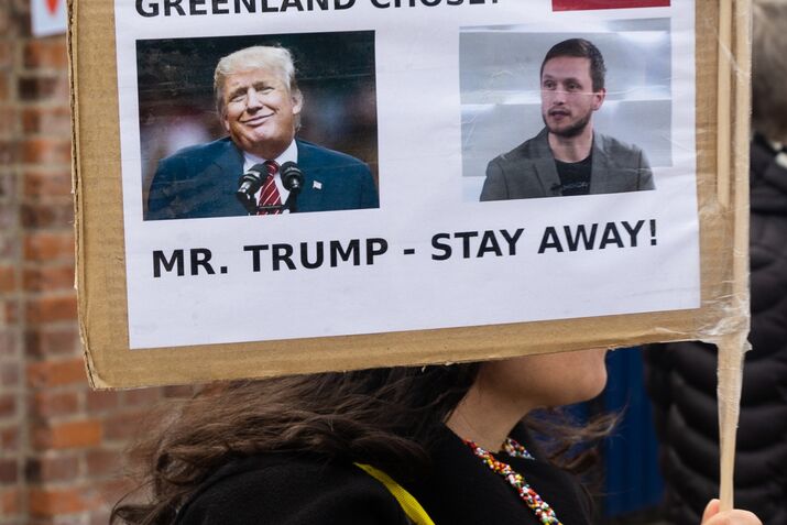 A protester holds a placard with a photo of United States