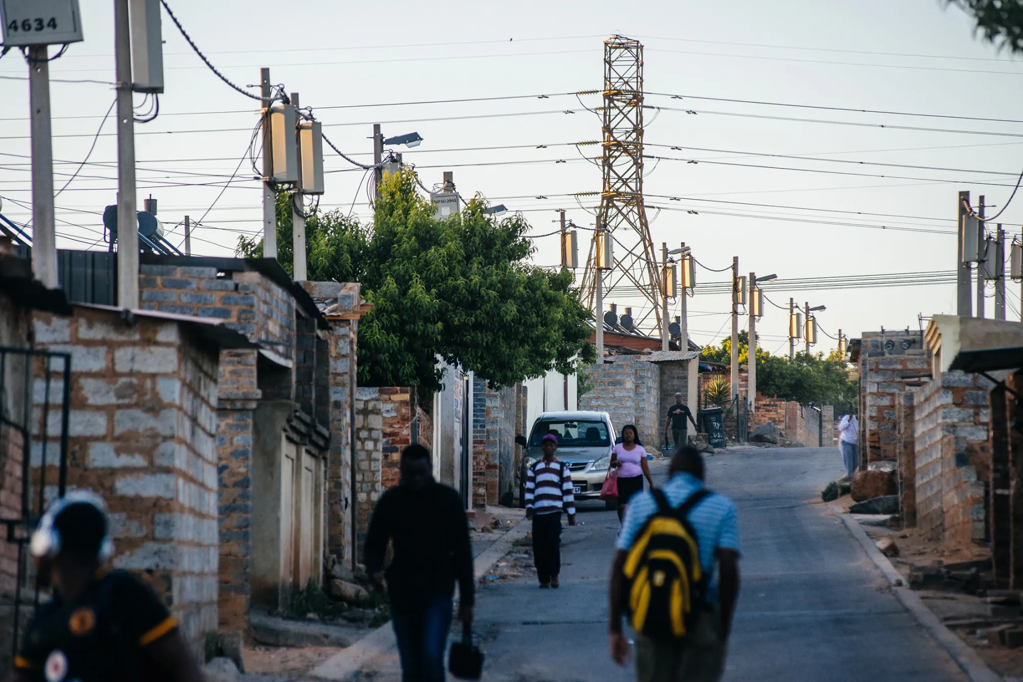 A pylon tower carries electrical power lines over residential shacks and electrical boxes in the Alexandra township outside Johannesburg, South Africa.
