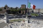 The Italian national flag flies near a monument to the unknown soldier in Rome.